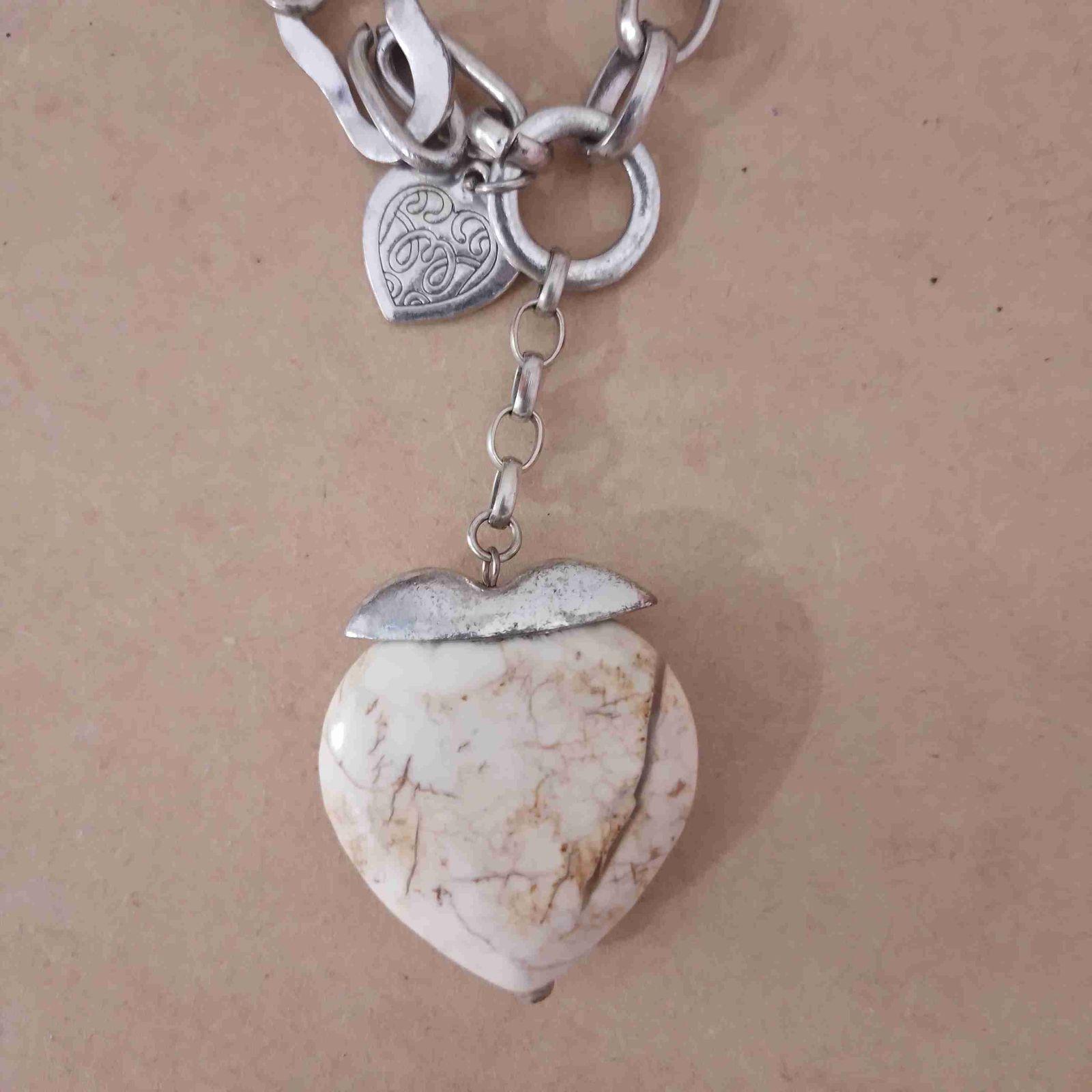 Collar de metal plateado con dije de piedra blanca en forma de corazon, foto 2 de 3
