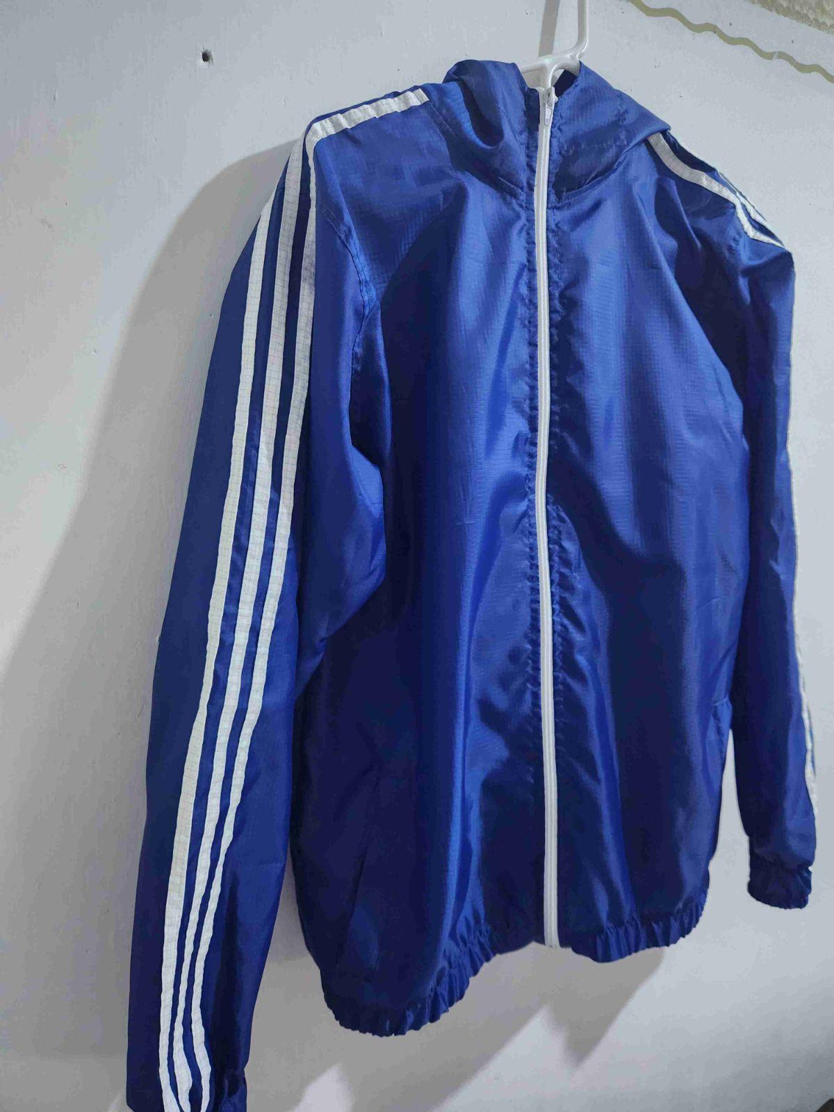 Chaqueta deportiva azul con capota y rayas blancas, foto 2 de 2