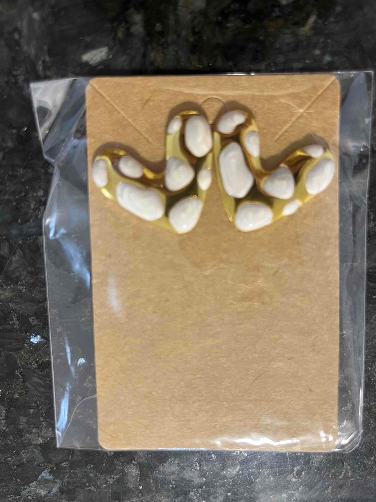 Zarcillos dorados con detalles blancos en forma de corazón, foto 3 de 3