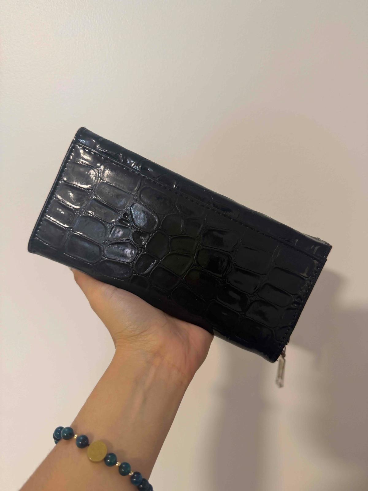 Cartera de mano negra con textura, foto 2 de 2
