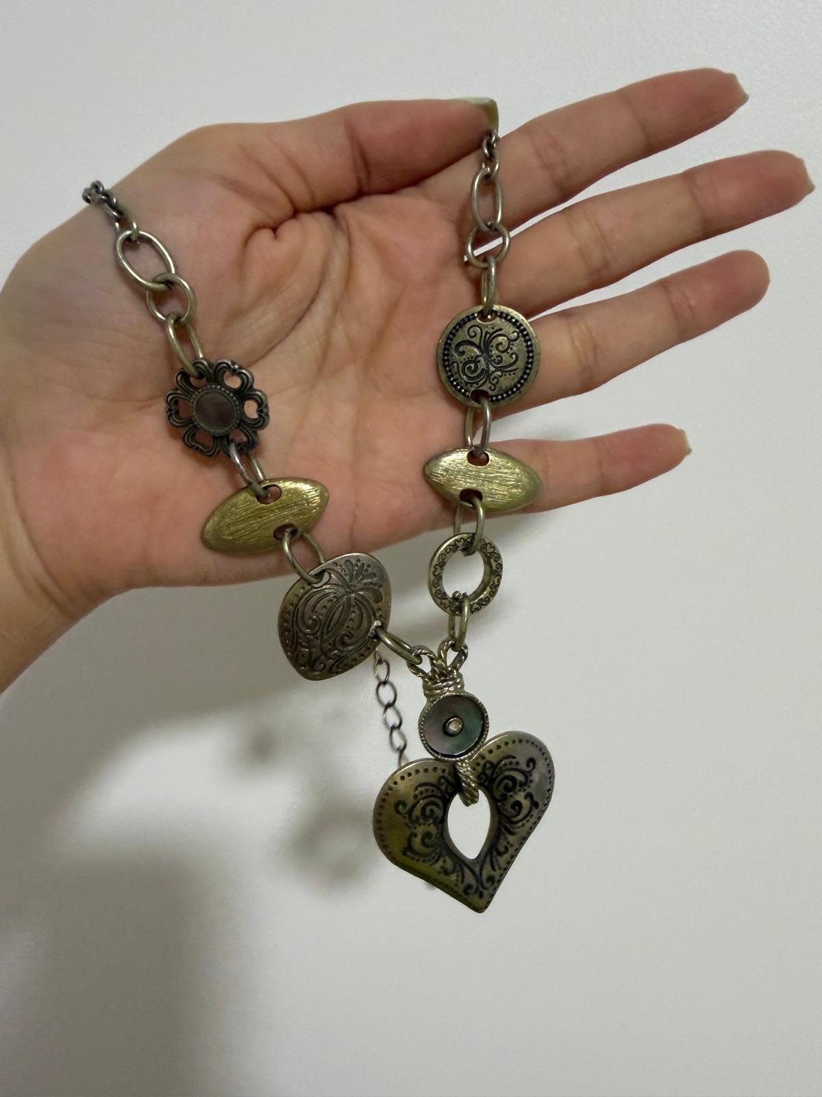 Collar de metal dorado con dijes de corazón y círculos grabados, foto 1 de 3