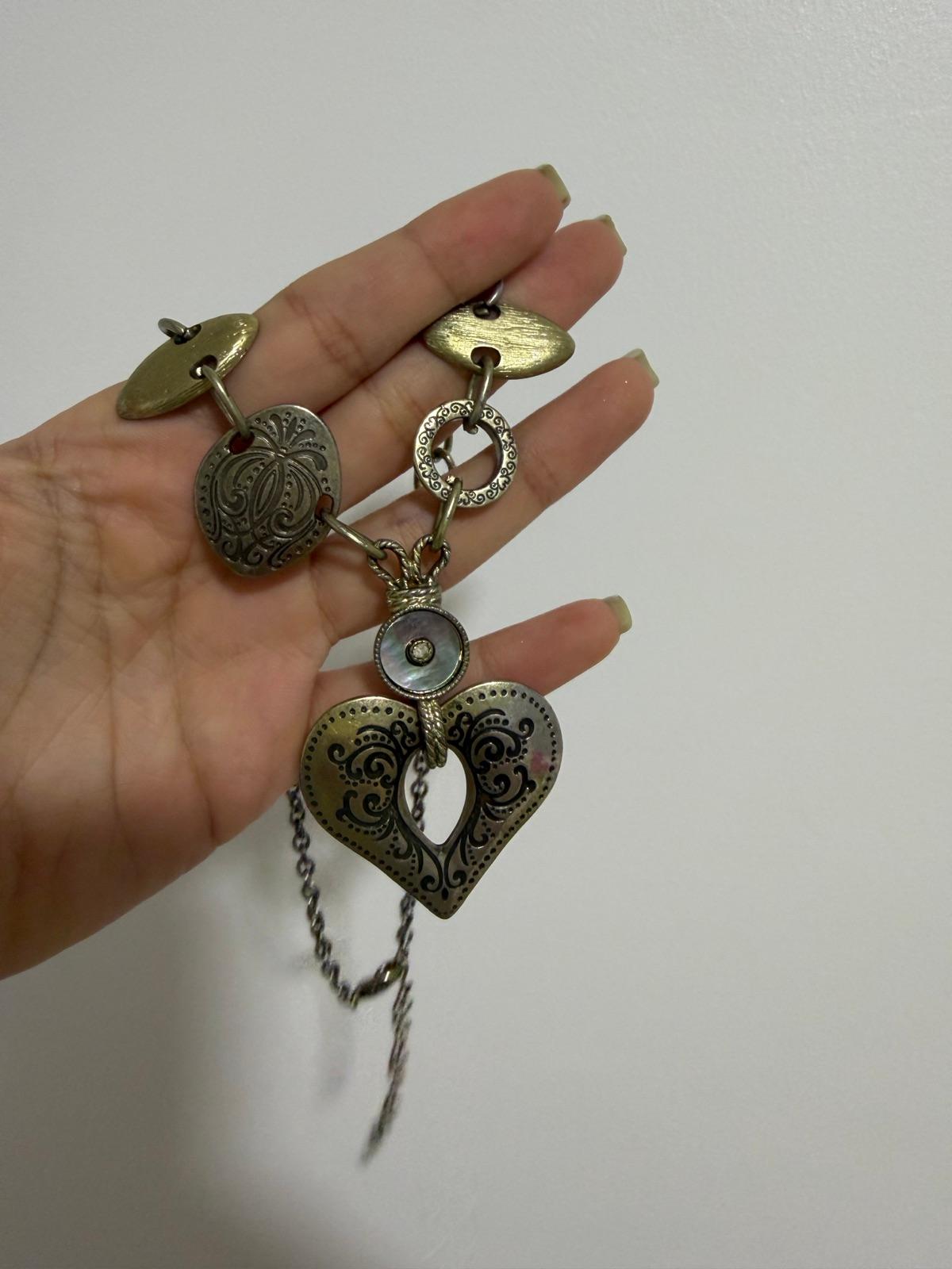 Collar de metal dorado con dijes de corazón y círculos grabados, foto 2 de 3