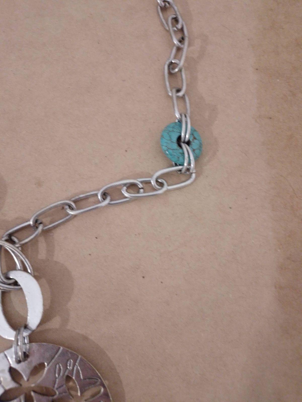 Collar de metal plateado con dije circular y flores, foto 3 de 4