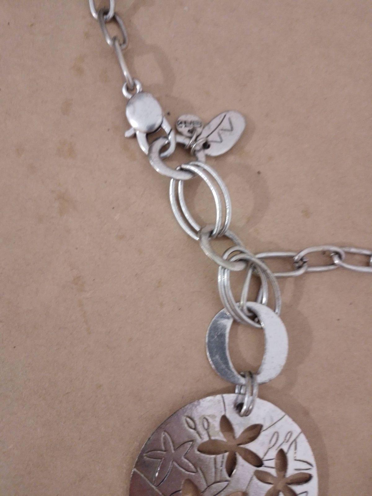 Collar de metal plateado con dije circular y flores, foto 4 de 4